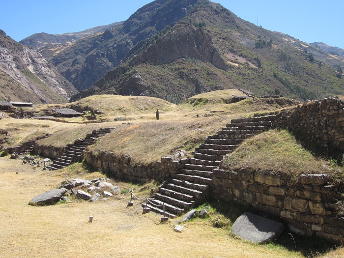 Die Mauern der Ruine Chavín de Huantar sind mit Gras überwachsen. 